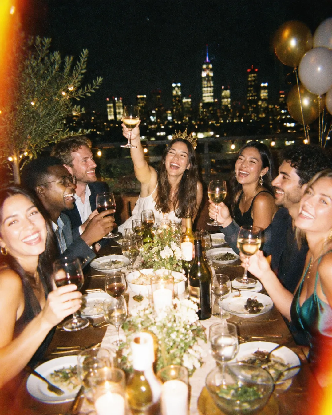 Friends toasting at a rooftop birthday dinner