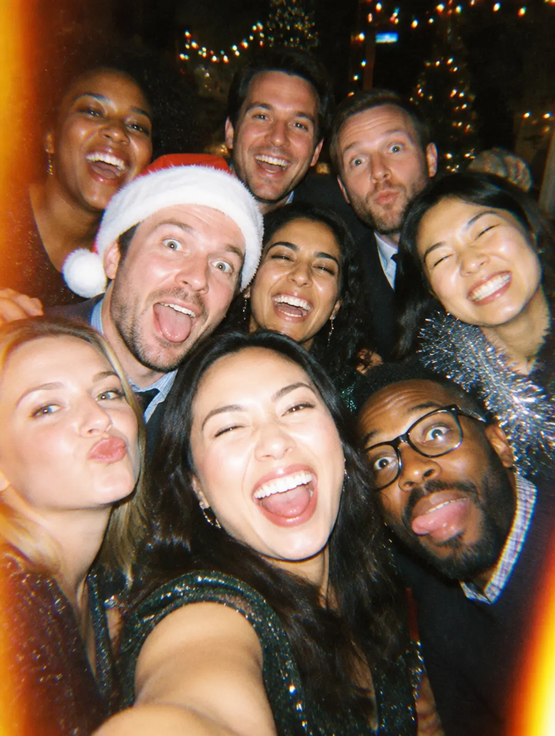 Coworkers taking a group selfie at the office holiday party