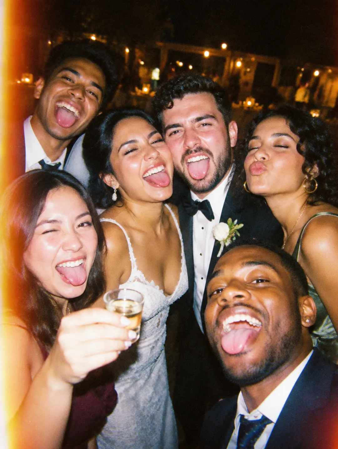 Bride and groom pulling faces in a selfie with friends