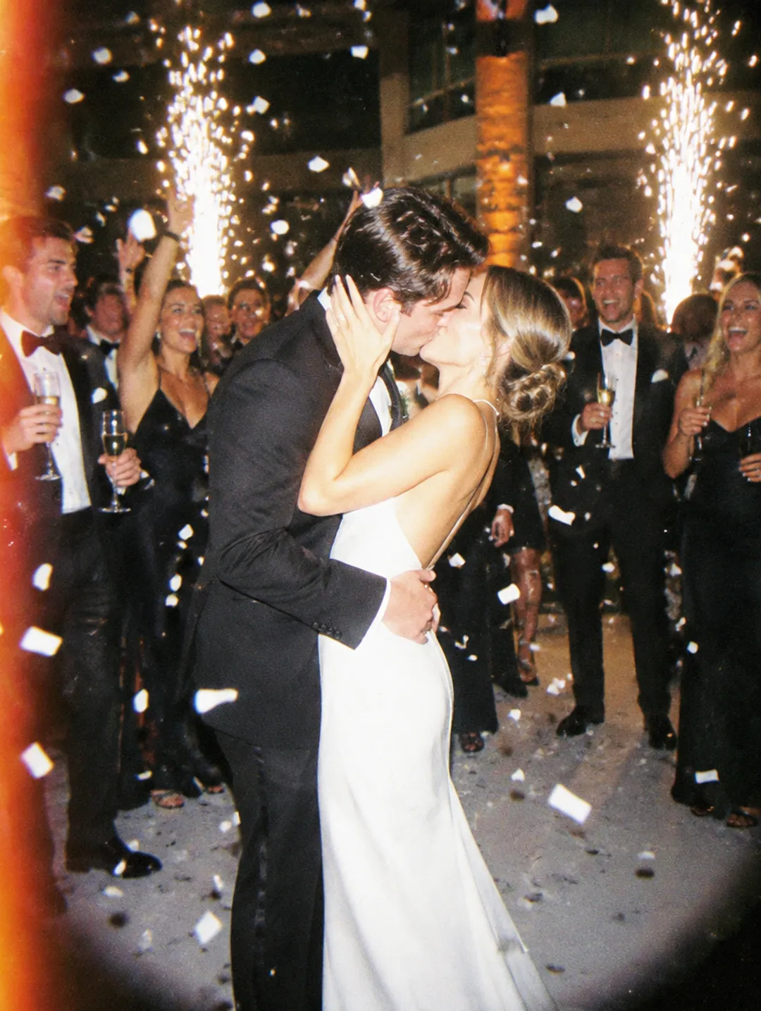Newlyweds kissing under sparklers